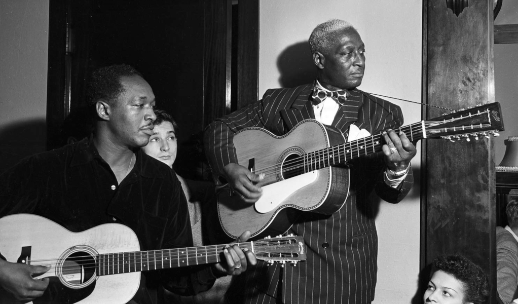 Lead Belly and Josh White perform in photographer Stephen Deutch’s apartment for a fundraiser for the Committee of Arts And Sciences in Chicago (1940)